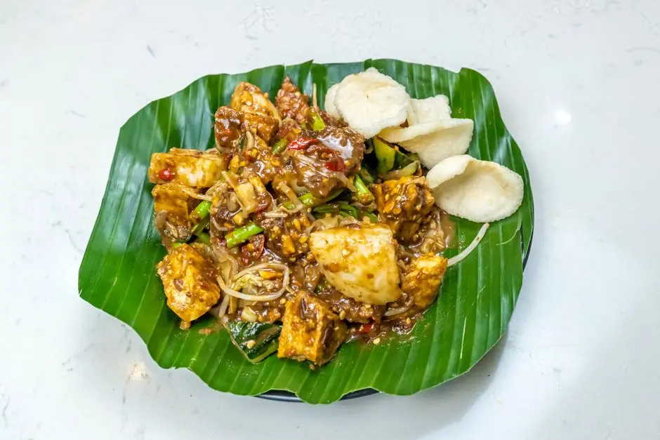 Tumis toge tahu dengan tahu goreng di atas piring saji